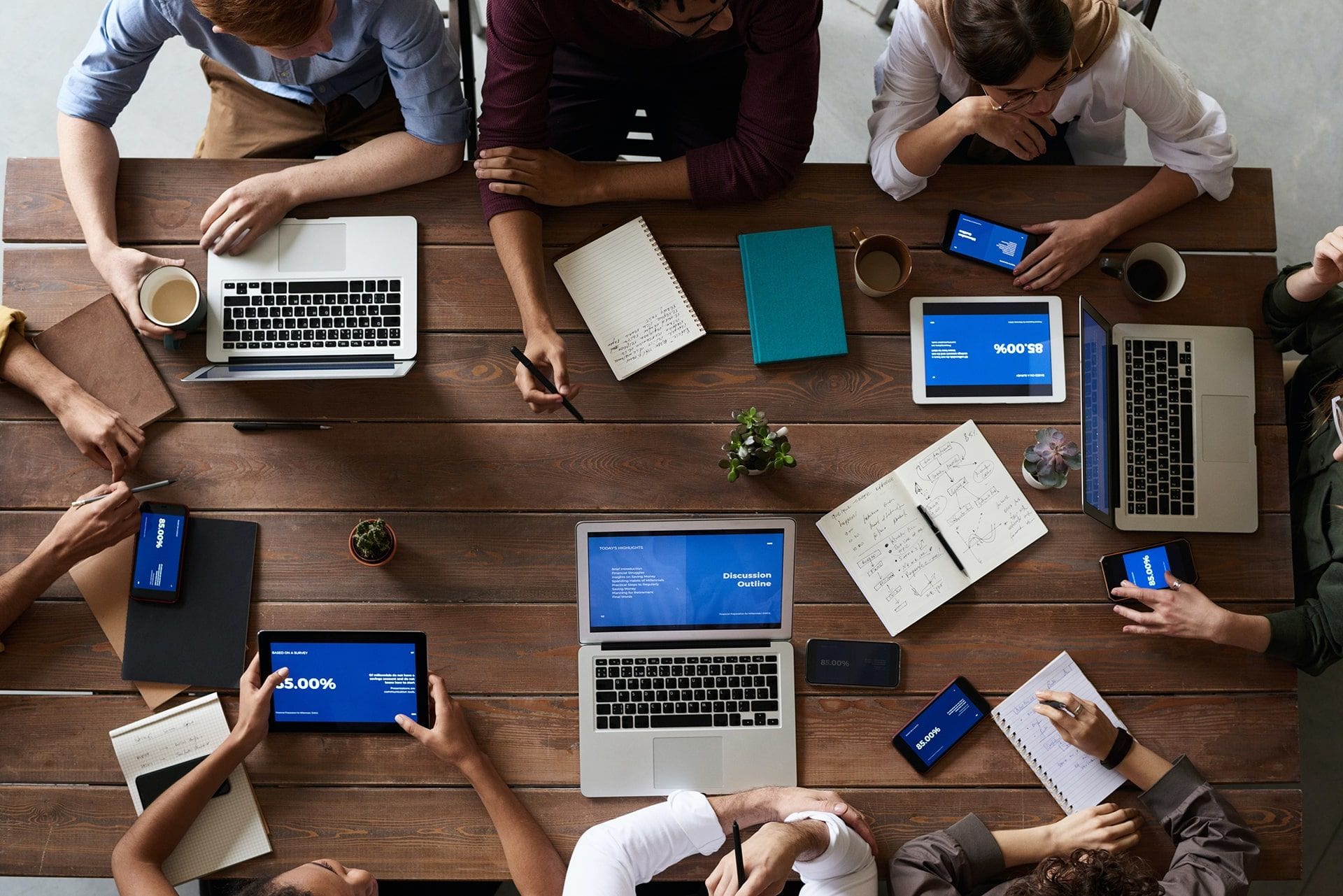 Agencia de Marketing Digital, personas trabajando con ordenadores y libretas